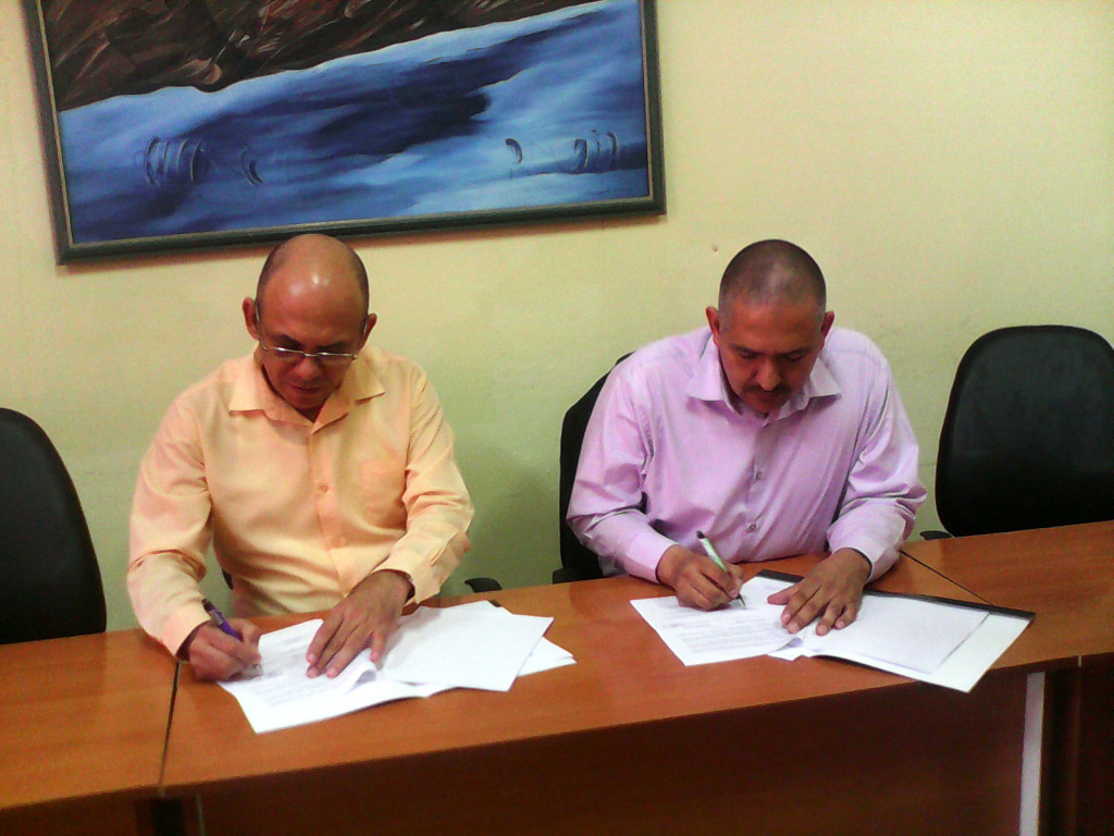 El Dr.C Reynaldo Velázquez Zaldívar, rector de la Universidad de Holguín y el Dr. Alfonso Vega López proceden a la firma del convenio. Desarrollado en la Sede "Celia Sánchez Manduley" el 31 de mayo de 2016. UHO FOTO/Yudith Rojas Tamayo