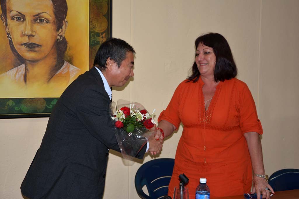 El Excmo Sr. Masaru Watanabe, Embajador de Japón en Cuba, recibe un ramo de flores de manos de la Dr.C. Isabel Torres, Vicerrectora Primera de la Universidad de Holguín. UHO FOTO/Luis Ernesto Ruiz Martínez-Dircom