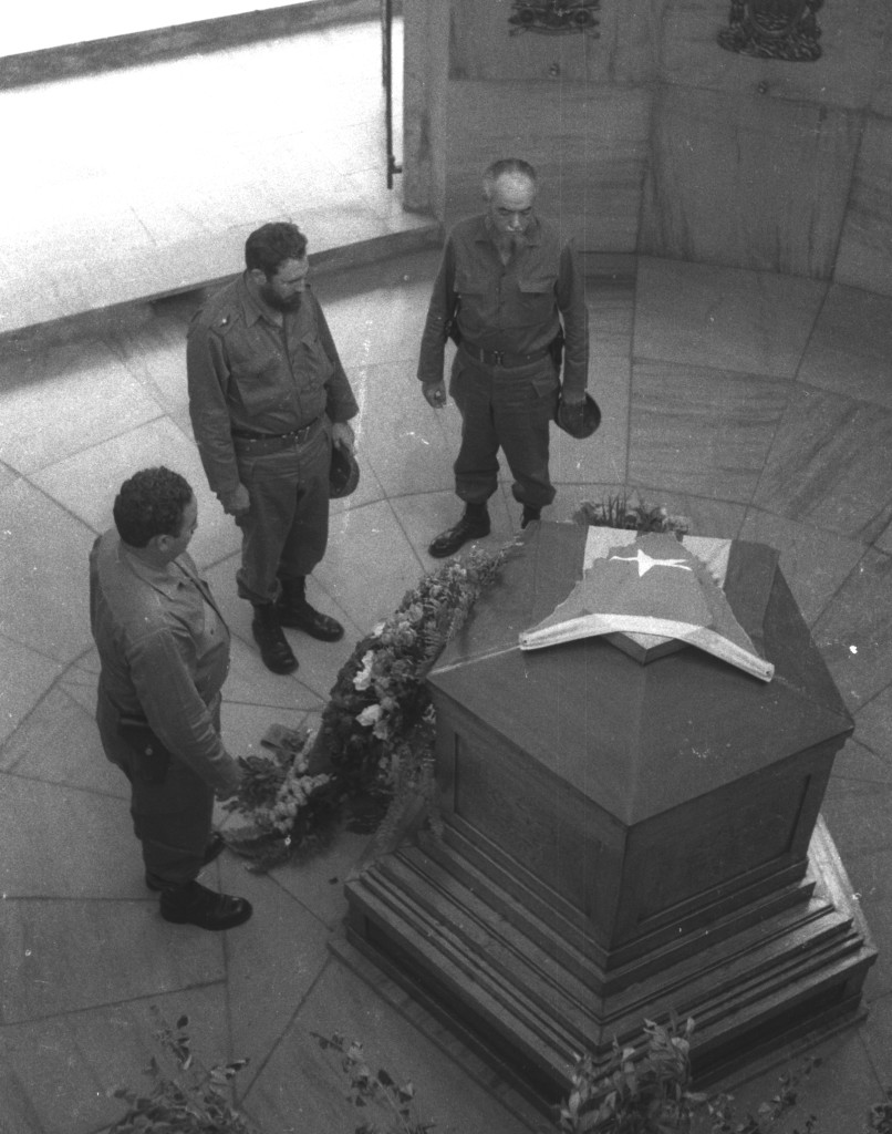 Fidel rinde tributo ante la tumba de José Martí en el Cementerio Santa Ifigenia, lo acompañan los comandantes Armando Acosta (Secretario del PURSC en Oriente) y René Vallejo (médico personal). Santiago de Cuba, 27 de julio de 1964. Foto tomada por Liborio Noval.
