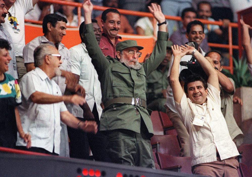 Cuban president Fidel Castro (C) participates in the "wave" while watching the Pan American games women's basketball semi-final between Cuba and the United States of America, 10 August 1991, in the Latinoamericano stadium. Cuba won 86-81.