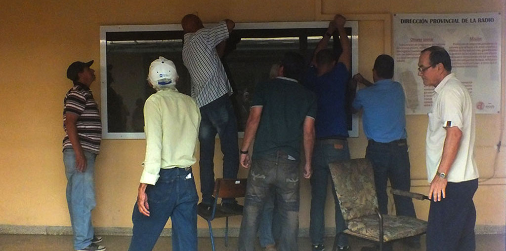 Yordanis ayuda a dsemontar los cristales del estudio de grabaciones. Foto: Lisandra Cardoso/Radio Angulo.